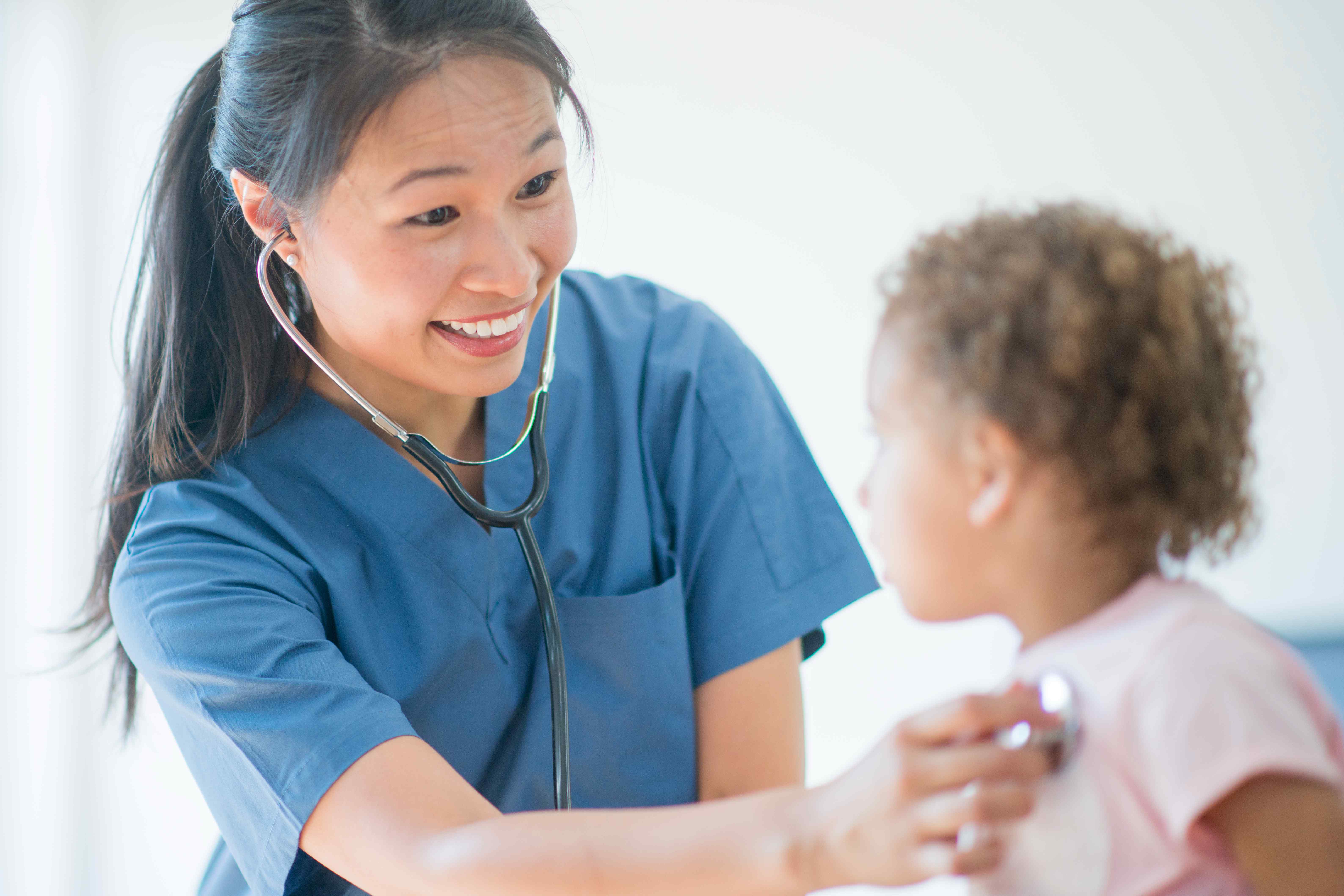 Our Storyイメージ／小児の患者さんに微笑みかける女性医師